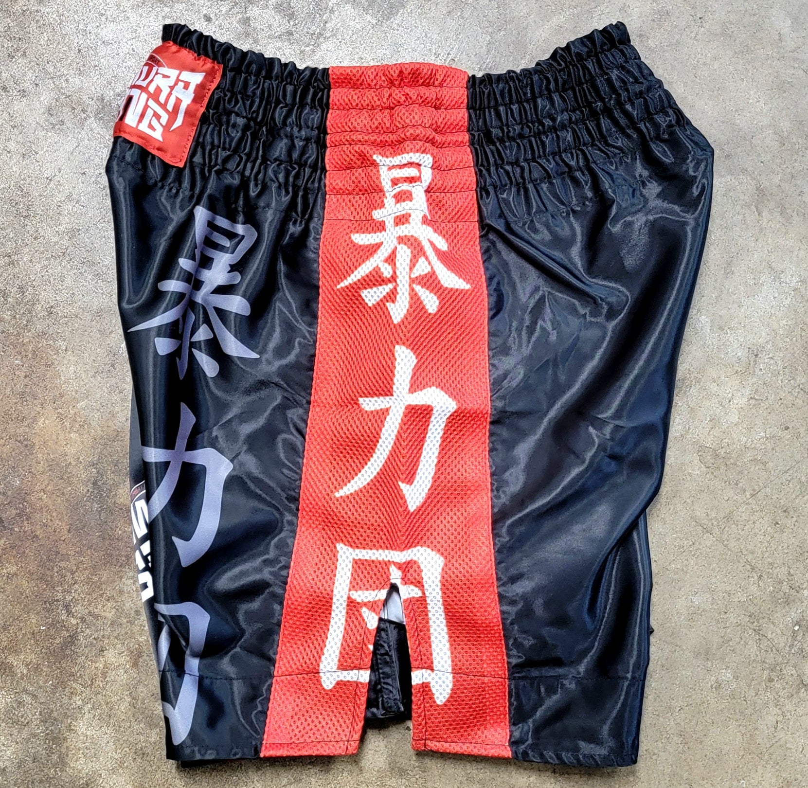 Black pants with red and white text on a textured surface