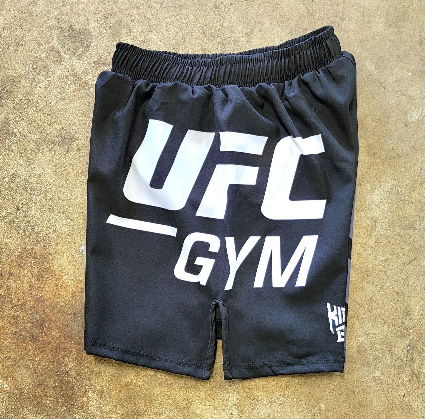Black shorts with white and gray UFC Gym logos